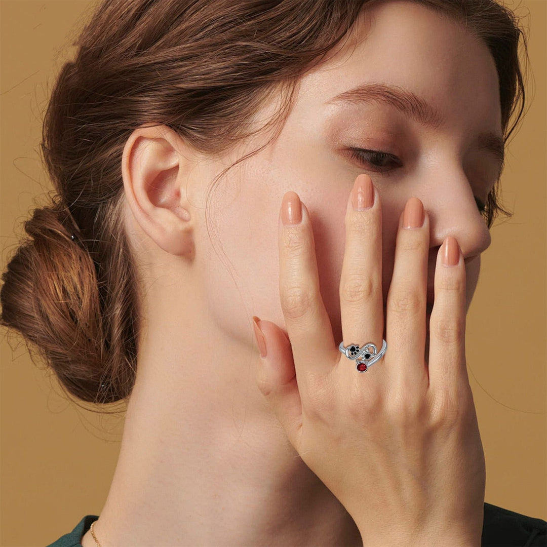Adjustable ring with black paw print and red gemstone
